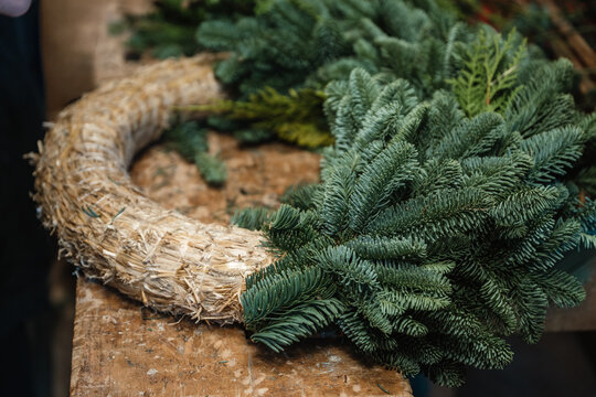 Unfertiger Adventskranz aus Stroh und frischen Tannenzweigen