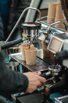 Barista bereitet Espresso in Pappbechern zu
