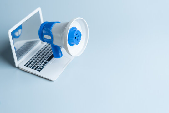 A megaphone stands on a laptop keyboard. Digital marketing, online promotion, social media outreach, announcement concept. Copy space for text.