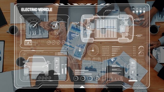 A top-down view of a conference table with hands and papers discussing electric vehicle technology, featuring a virtual dashboard with data and analytics for strategic insights. Raster - Powered by Adobe