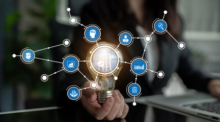 A professional setting showcases a light bulb held by a business individual, surrounded by digital icons representing growth and innovation for creative concepts. Crux