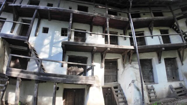 Preserving medieval defensive architecture, the inner wall of Prejmer Fortified Church features old wooden stairs and balconies leading to small rooms. UNESCO site of Romania in Transylvania
