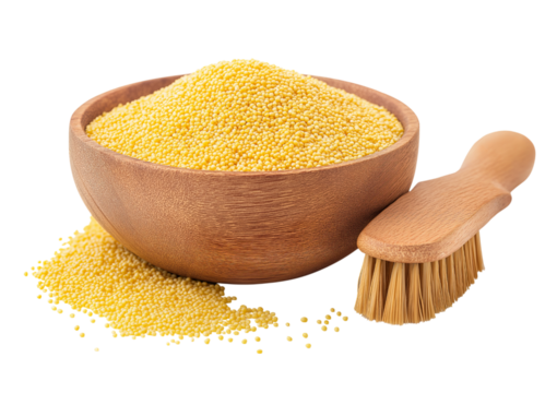 Wooden bowl overflowing with bright yellow millet grains next to a small wooden brush isolated on a transparent background