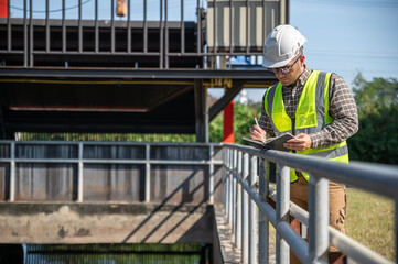Field engineer taking notes during an outdoor inspection of the industrial water management facility