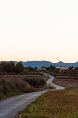 Winding road in a landscape with mountains at sunset