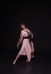 Woman dancing in national costume on black background