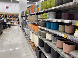 Colorful ceramic planters on display in a home goods store aisle