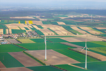 Aerial view wind turbines among agricultural fields highlighting renewable energy use in rural...