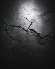 Dramatic Cracked Concrete Wall Texture Illuminated by Spotlight, Grayscale Abstract.
