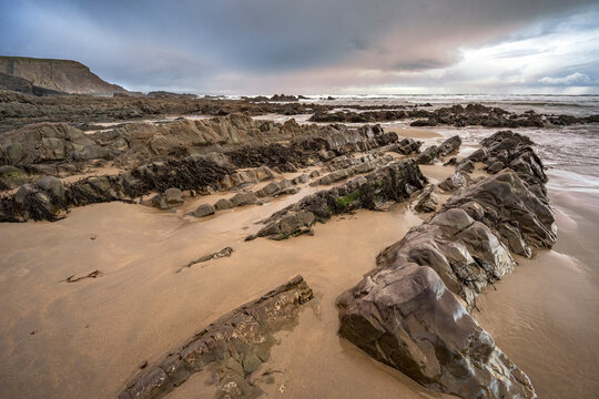 Dramatic storm clouds gathering at dawn on Cornish beach