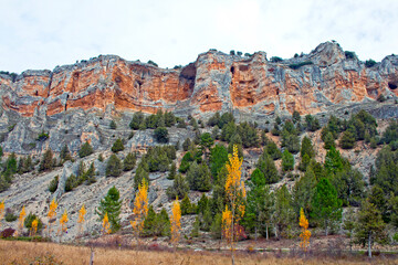 Autumn Landscape with Majestic Rock Cliffs and Golden Trees