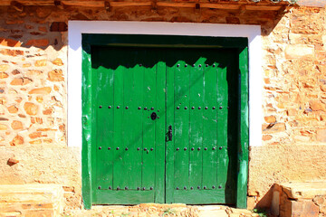 Vibrant Green Rustic Door in Traditional Stone Wall