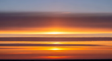 Fototapeta premium Beautiful Sky with Layers of Clouds During Sunset Creating Scenic Landscape with Orange and Purple Tones 150 Characters