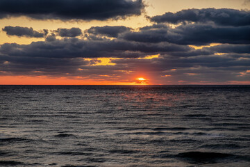 Dramatic sunrise over the Black Sea in Obzor with colorful sky and gentle waves on the calm morning horizon