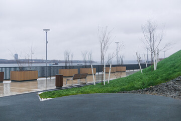 Empty benches on the embankment of the lake in cloudy weather