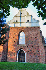 Zabytkowy kościół romański z kamienną podstawą i barokowym, ozdobnym szczytem w spokojnym otoczeniu parku. Lubiń – kościół poewangelicki w stylu romańskim. © Pol Badger