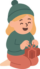 A cheerful little girl in a green winter hat and sweater happily opens a wrapped gift while kneeling on the floor.