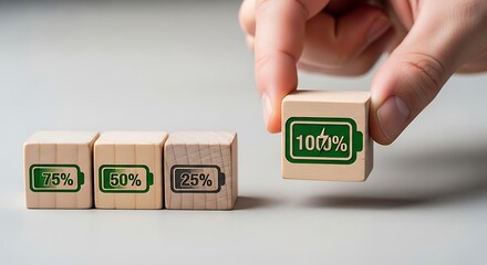 Hand placing a wooden block showing 100 percent battery charge next to blocks showing lower charge levels