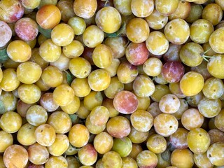 Fresh gold and purple plums at a french country market