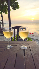 Wine glasses on wooden table at sunset, Island Ko Nang Yuan, Surat Thani, Thailand, Southeast Asia.