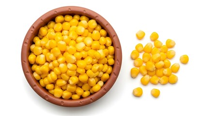 Yellow corn kernels in clay bowl with scattered kernels