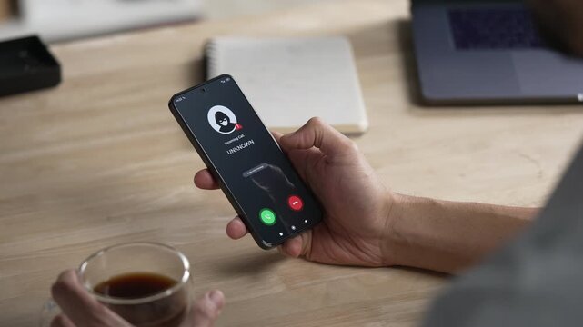 Receiving call from unknown person or Scammer, Hands holding phone with incoming call from scammer