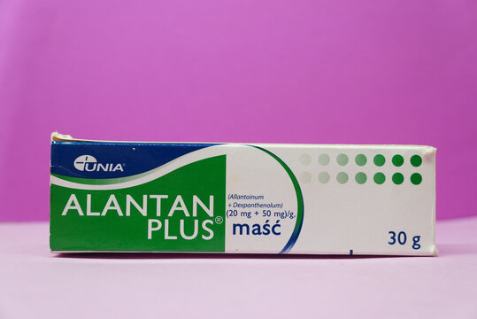 Alantan Plus ointment tube on a vibrant pink background, close-up shot.