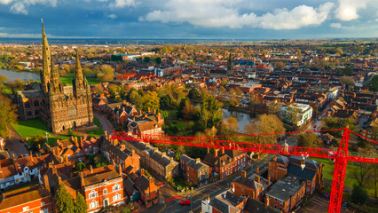 Lichfield historical landmark towering over main street traffic and crane