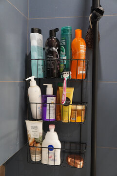Bathroom shower organizer filled with various toiletries and bath products