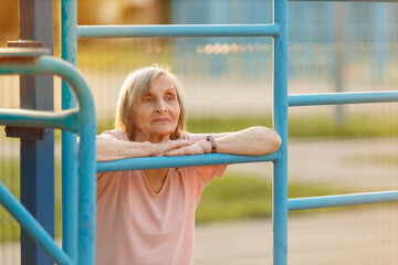 Obraz premium Serious Senior Woman Resting at Outdoor Gym. Healthy Life Concept.