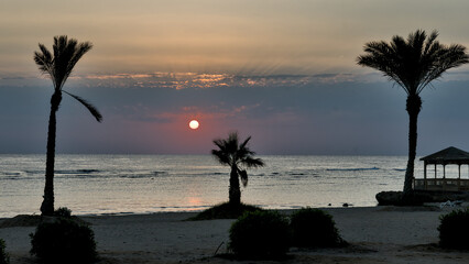 Sunrise over the Red Sea shoreline in an Egyptian hotel resort, casting warm light across the calm coastal scenery.
