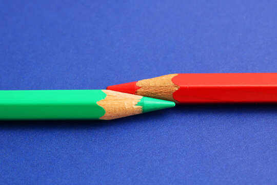 A green pencil next to a red pencil, complementary colors
