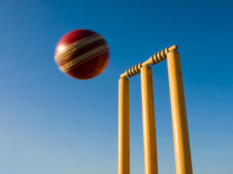 Exciting cricket match action as ball speeds toward wickets, perfect for sports promotions and dynamic visuals, capturing the thrill of competition