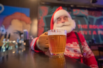 Santa Claus drinking beer at a bar. 