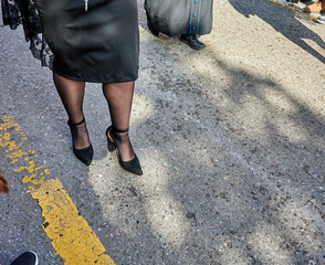 A pair of Cofradía members in matching red robes pause quietly with cirios along Calle Reyes...