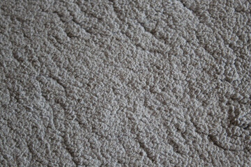  a textured surface that appears to be a light gray fabric or material. The surface features a wavy pattern, adding depth and interest to the visual.