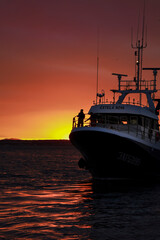 Fototapeta premium Fishing Boat returning to the Port of Santa Pola at sunset