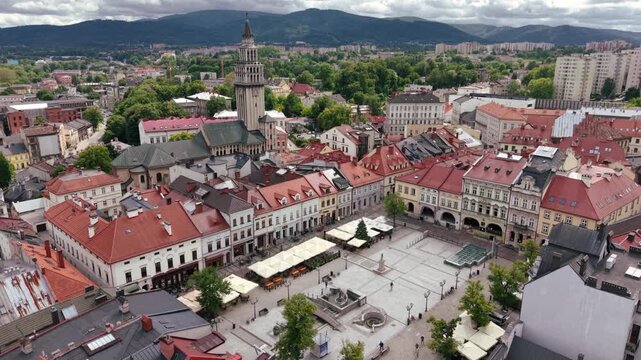 Aerial view of historic town square in Bielsko-Biala, Poland with colorful buildings and mountains in the background.