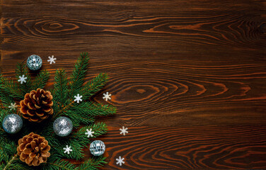 Fresh fir branches and large pine cones on a dark wooden background