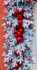 Christmas decoration made of fir branches covered with frost and red glass balls