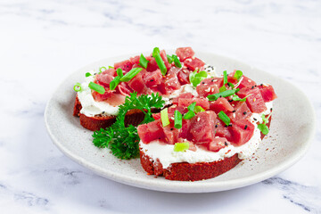sandwiches, rye bread with cream cheese, sliced tuna fillet with green onions, breakfast, on a marble table, homemade,