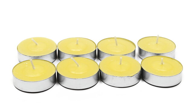 Yellow decorative tea light candles in aluminum holders isolated on white background - Powered by Adobe