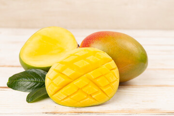 Fresh ripe mango with leaves on wooden table