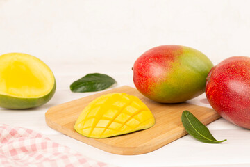Fresh ripe mango with leaves on wooden table