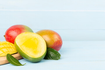 Fresh ripe mango with leaves on wooden table