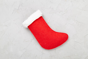 Christmas sock on concrete background, top view
