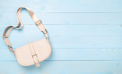 Beige small bag on wooden background, top view