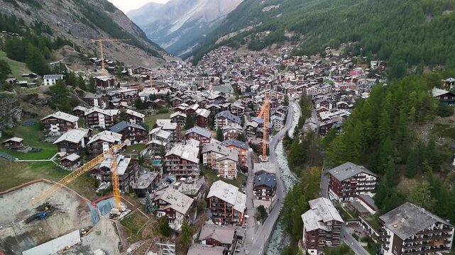 Aerial shoot of Midday Zermatt with constructions crains visible city alpine village Switzerland