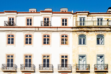 Obraz premium Typical old buildings in Lisbon's lower town, with their windows with balconies, lanterns, and decorative tiles. Lisbon, Portugal, 2023
