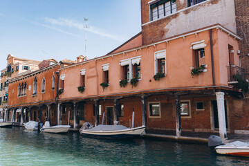 Colorful Venetian canal with historic buildings and moored boats